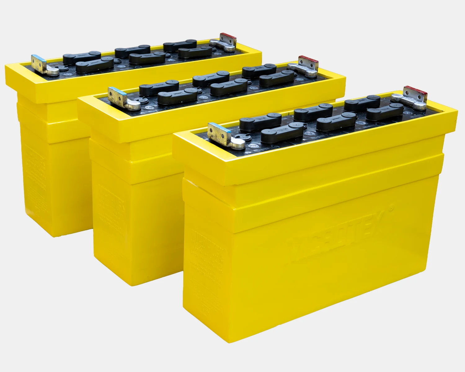 Microtex diesel locomotive starter batteries — yellow monobloc containers with flip-top vent plugs, built for railway cranking duty
