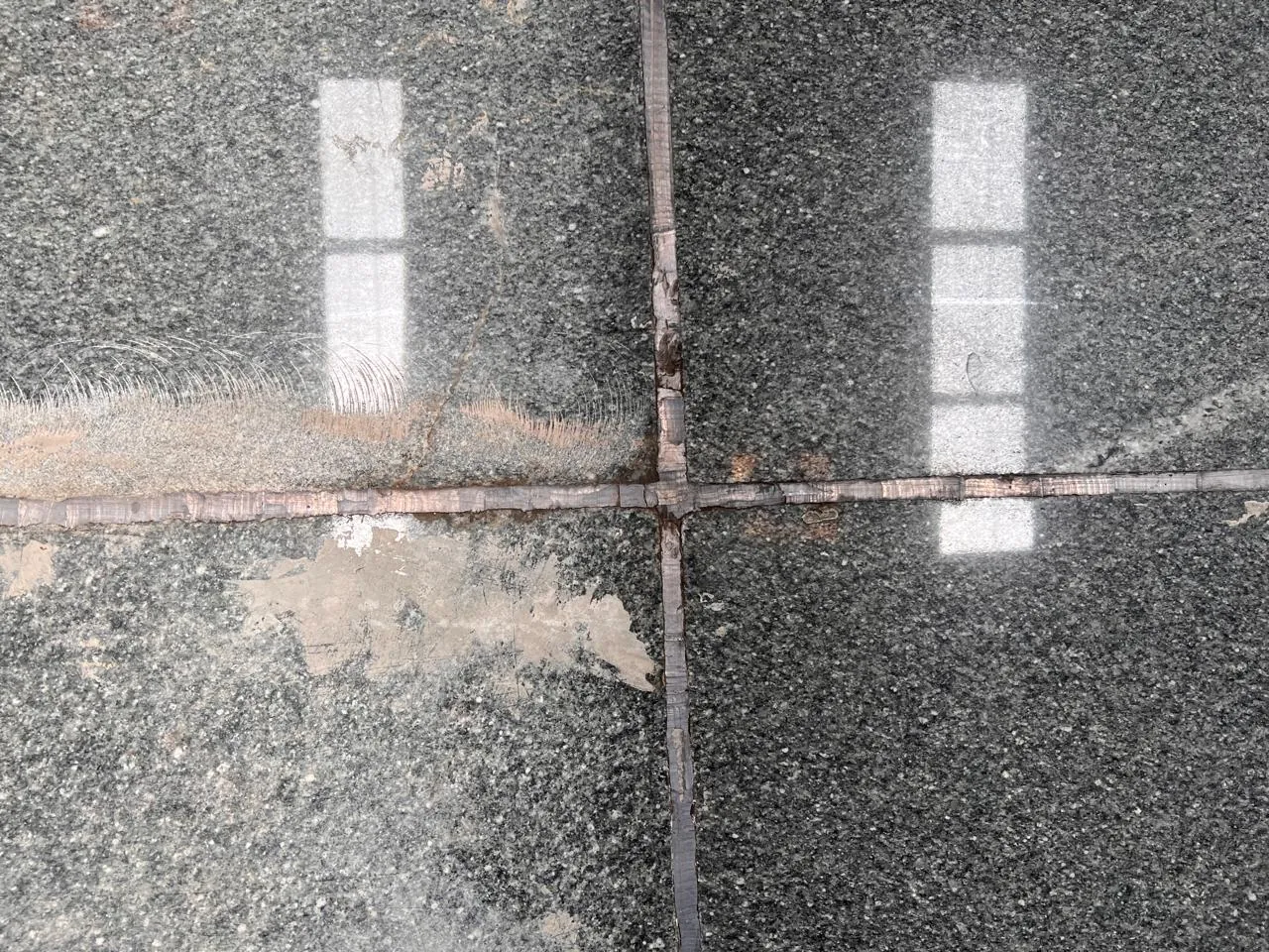Lead-filled joint between granite slabs after years of service, battery formation floor